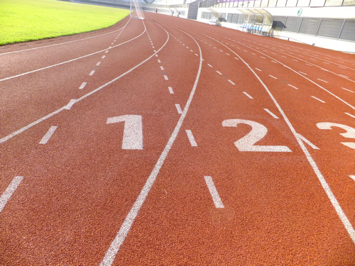 实拍深圳宝安体育馆足球场景观，有工人在维护有市民在跑步