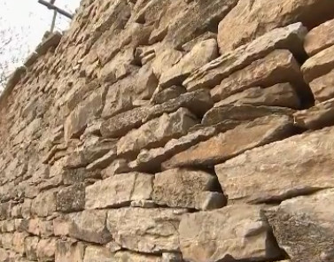 用石头建房的老人,老人用水泥砖建房