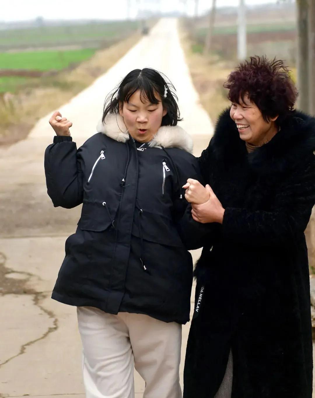 残疾女孩用嘴叼木棍写字,残疾女孩嘴叼木棍