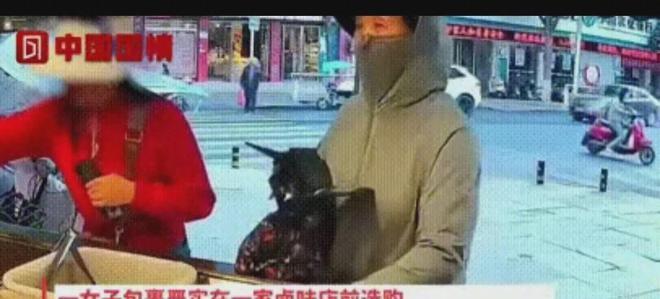 女人趁老板不注意偷偷把红烧马德利塞进包里，旁边的顾客一脸愕然